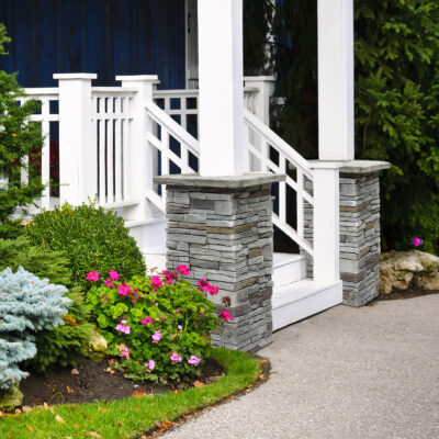 a white pillars and a walkway with a white railing